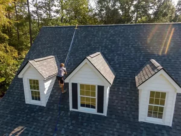 Roofing expert inspecting shingled roof